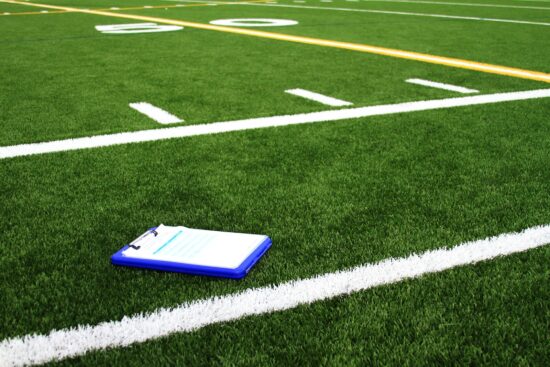 Playbook on a football field in a youth scrimmage.